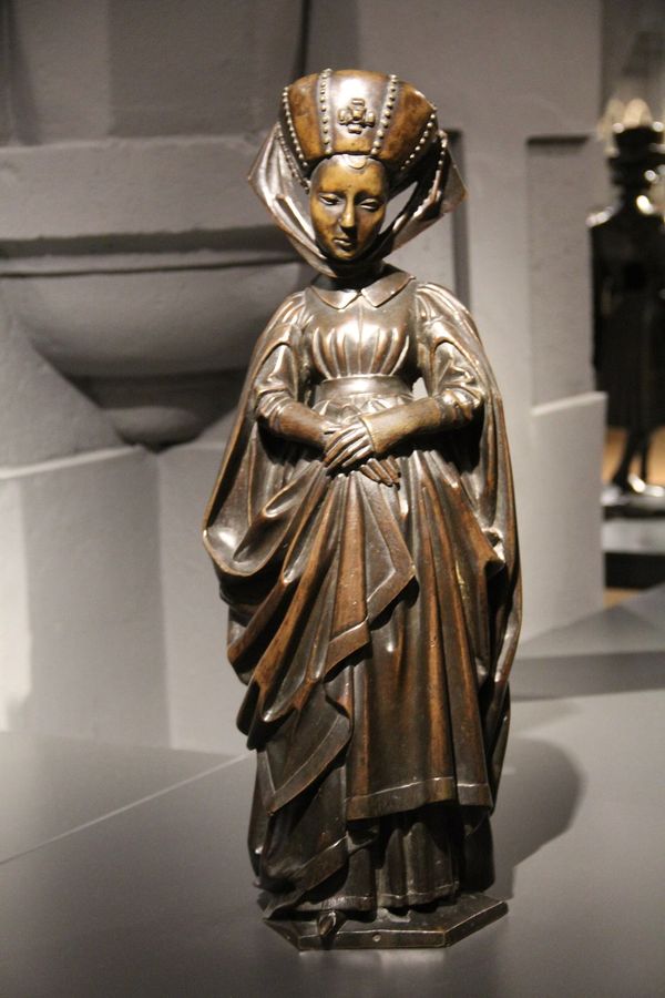Tien pleurants van het praalgraf van Isabella van Bourbon. Pleurant gekleed in houppelande en een tulband met parels op haar hoofd, afkomstig van het praalgraf van Isabella van Bourbon (1436-1465)