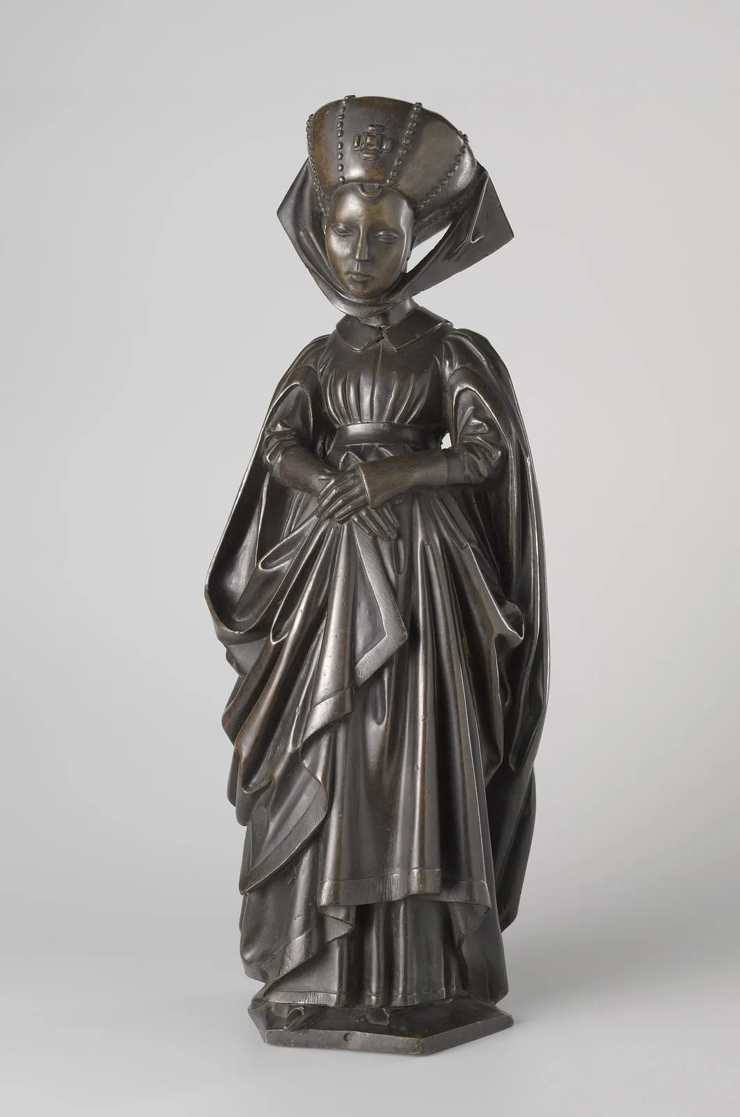 Tien pleurants van het praalgraf van Isabella van Bourbon. Pleurant gekleed in houppelande en een tulband met parels op haar hoofd, afkomstig van het praalgraf van Isabella van Bourbon (1436-1465)